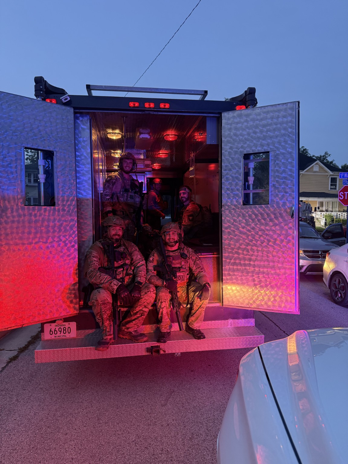 First responders inside an armored vehicle under emergency lighting